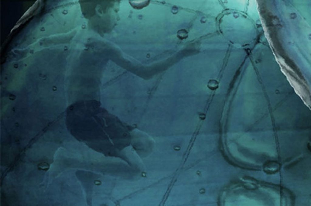 Fotografia de Sonia Guggisberg sobre a obra Submersão, onde há uma pessoa submerda em uma piscina